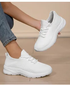 Close-up of white lightweight flyknit sneakers for women with breathable mesh texture detail
