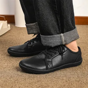 Close-up shot of men's minimalist black leather wide toe barefoot shoes with laces