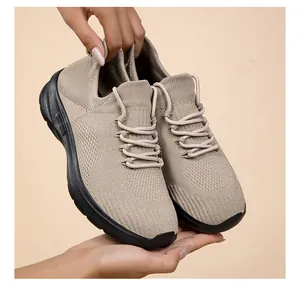 Detailed view of lightweight beige fly-knit sneakers featuring breathable mesh and black soles