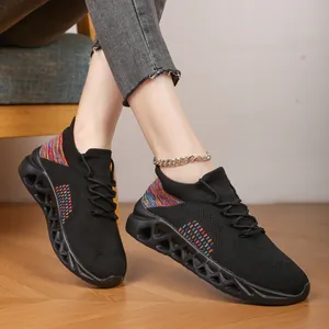 Close-up of black breathable fly-knit sneakers with colorful accents and hollow soles