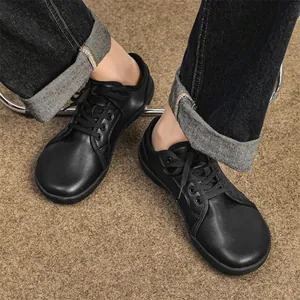 Detailed view of black leather wide-toe barefoot shoes with non-slip flat soles