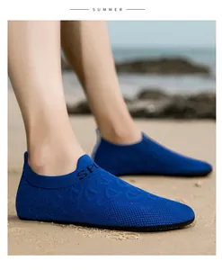 Scarpe da scoglio blu in tessuto sulla spiaggia per attività acquatiche estive