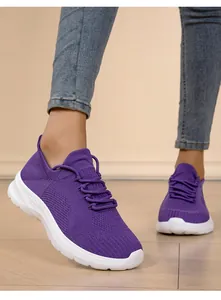 Close-up detail of lightweight purple fly-woven knit sneakers for women worn on feet