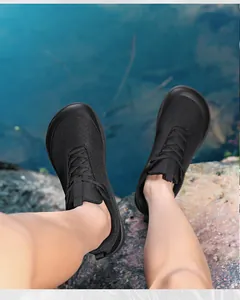 Detailed shot of black wide-toe barefoot hiking shoes worn on rocky outdoor terrain