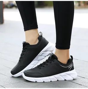Vista laterale di sneakers casual da donna in pelle nera con suola bianca