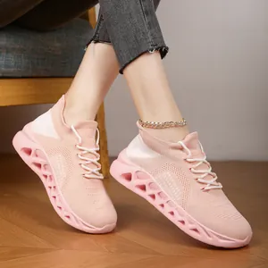 Breathable pink fly-knit sneakers worn on model legs with a detailed mesh texture view