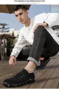Close-up of men's lightweight black fly-knit casual sock shoes with colorful patterned soles.