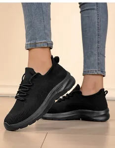 Detail of breathable black fly-knit sneakers on model with casual jeans