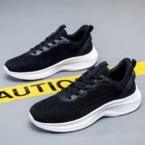 Détail de baskets noires en maille pour hommes avec des semelles blanches épaisses.