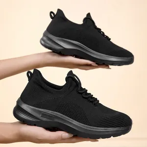Breathable lightweight black flying woven leisure sneakers for women on plain background