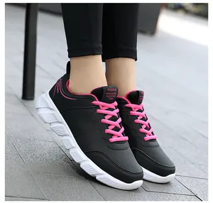 Primo piano di sneakers in pelle nera con lacci rosa e suole bianche da donna