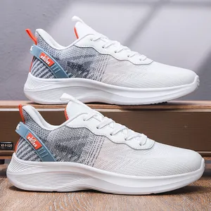 Vue latérale de chaussures de course en maille blanche avec semelles épaisses et détails orange.