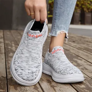 Close-up of grey breathable flying knit slip-on sneakers with white chunky sole