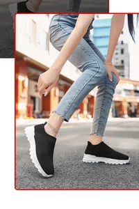 Detail van ademende zwarte fly-knit sok sneakers met dikke witte zolen op een straatmodel