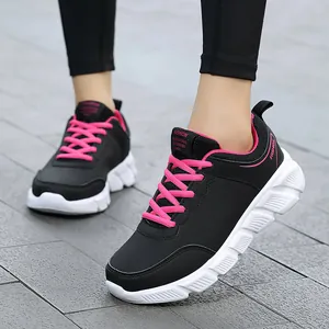 Sneakers da donna in pelle nera con lacci rosa acceso e suole bianche spesse