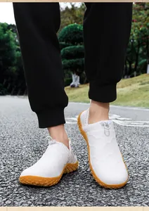Lightweight breathable white knit slip-on men's casual shoes worn in outdoor setting