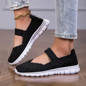 Detailed view of women's black woven elastic strap sandals with lightweight white sole