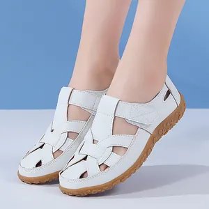 Nahaufnahme von weißen, hohlen, flachen Strandsandalen mit Gummisohlen für Damen.