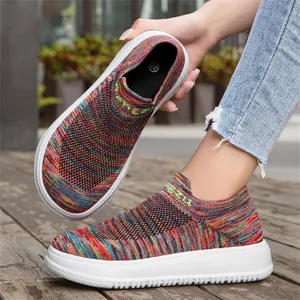 Close-up of rainbow flyknit slip-on sneakers with breathable mesh and white platform sole.