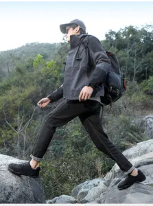 Men's black breathable barefoot hiking shoes shown in an outdoor rocky trail setting