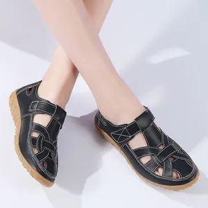 Detailansicht der schwarzen flachen Damen-Strandsandalen mit Gummisohle und Lochmuster