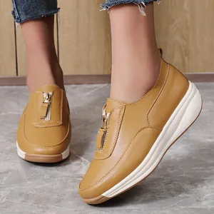 Gelbe Plateau-Lederhalbschuhe für Damen mit Reißverschluss und dicker weißer Sohle.