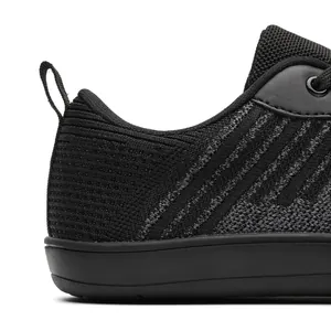 Close-up detail of black breathable fly-woven barefoot sports shoe with heel pull tab
