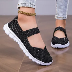 Close-up detail of black woven Mary Jane flats with sparkly accents and white comfort sole