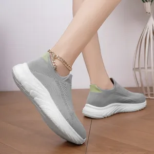 Detailed view of grey knit slip-on sneakers featuring breathable mesh and white sole