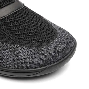Close-up detail showing the breathable fly-knit mesh texture on black barefoot sneakers