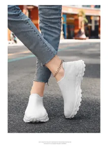 Gedetailleerd overzicht van witte ademende flyknit sneakers op straatplaveisel
