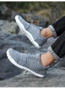 A detailed side view of breathable grey fly-knit lace-up men's casual shoes for hiking.