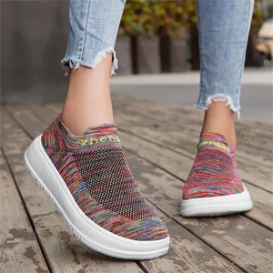 Detail view of colorful fly-knit slip-on sneakers with breathable mesh design on feet