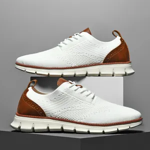 Detailed side view of white flyknit loafers with brown leather accents and breathable mesh