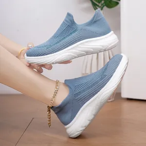 Detailed macro view of blue breathable knit slip-on sneakers with chunky white sole