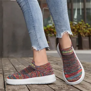 Detail of colorful fly-knit slip-on sneakers with wide toe and white platform sole
