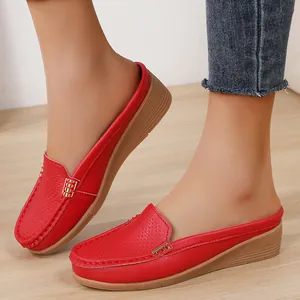 Detailweergave van de rode damesloafers met sleehak en elegante goudkleurige gesp.
