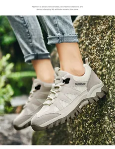 Dettaglio ravvicinato di scarpe da trekking grigie traspiranti su una roccia muschiata