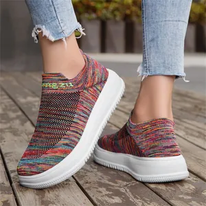 Macro view of vibrant multi-color flyknit slip-on sneakers featuring thick white platform soles.