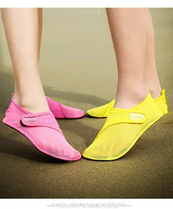 Close-up of pink and yellow quick-dry beach shoes worn on sand for outdoor swimming