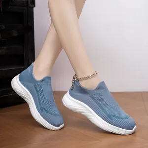 Side view of blue knit slip-on sneakers showing the textured mesh and thick white sole