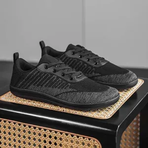 Detailed view of breathable black fly-knit barefoot shoes with a wide toe box design.