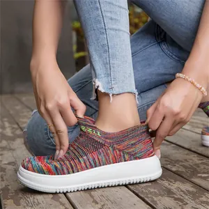 Close-up view of colorful flyknit slip-on sports sneakers with white platform soles