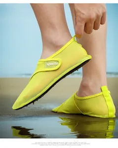 Close-up of neon yellow breathable mesh water shoes worn on a beach for outdoor activities