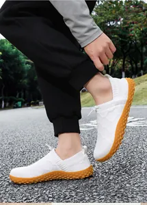 Breathable white fly-knit slip-on walking shoes with non-slip orange rubber soles