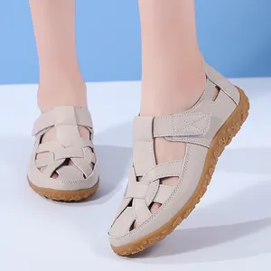 Detailansicht der beigen flachen Damen-Sandalen mit Blumenmuster auf der Sohle