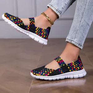 Macro view of colorful woven elastic band flat sandals for women shown on a model