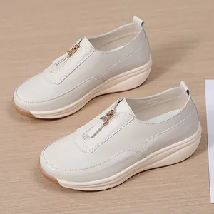 Bequeme beige Damen-Walkingschuhe mit Rocker-Sohle und Reißverschluss vorne.