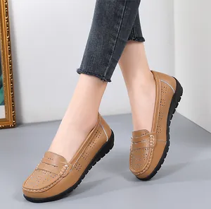 Detail view of comfortable tan leather loafers with white stitching and hollow patterns