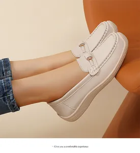 Gros plan de mocassins beiges à bout large avec boucle décorative